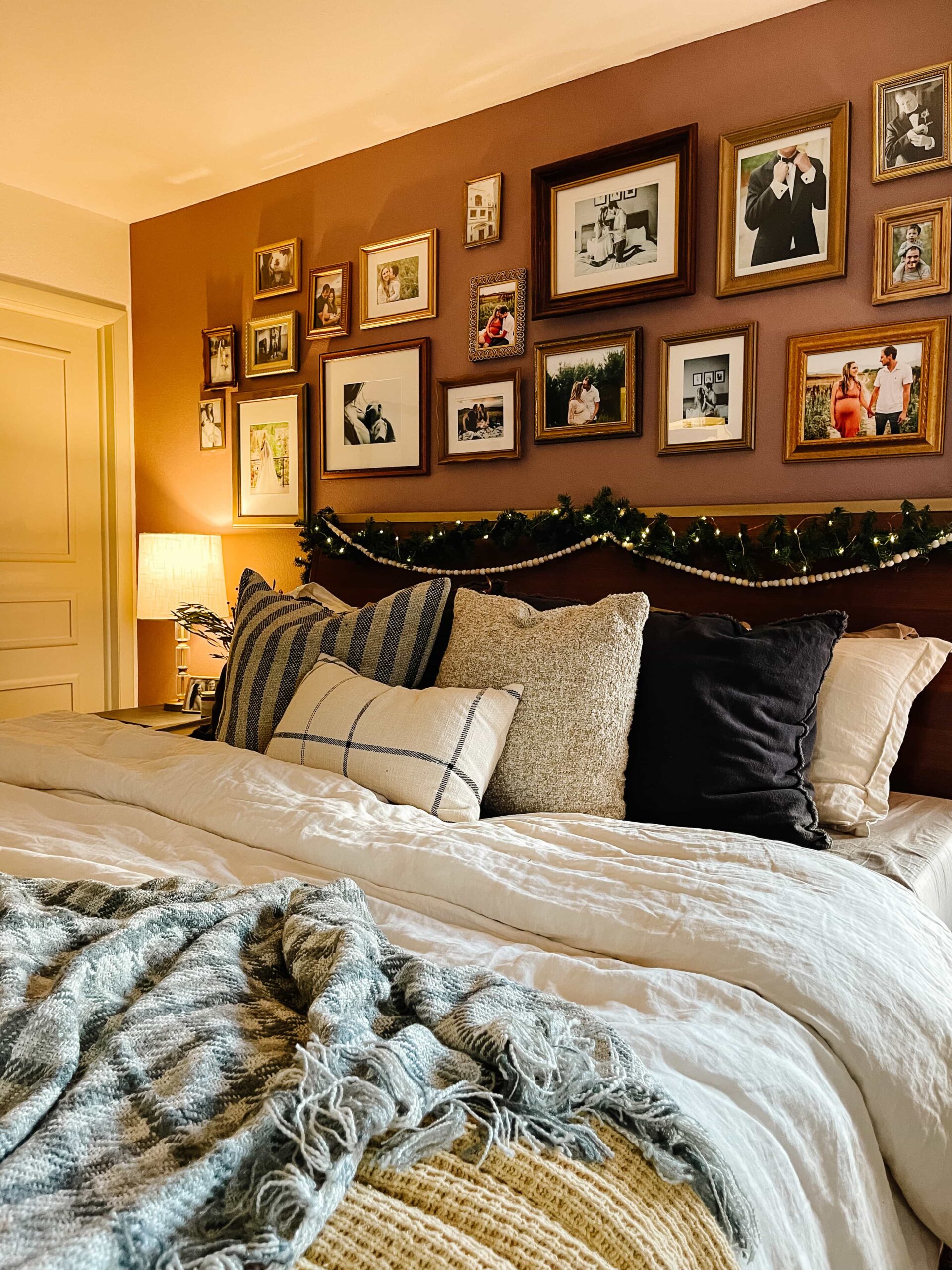 Warm winter bedroom with layered bedding, cozy textures, and a gallery wall, styled to feel calm and inviting during a winter home reset.