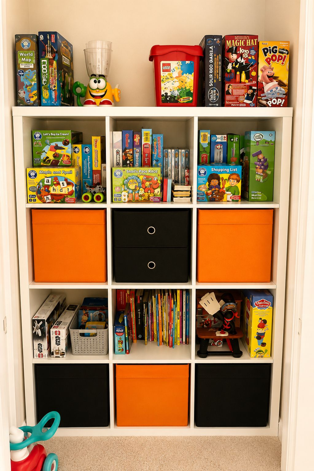 Kids’ playroom featuring a white IKEA KALLAX storage unit with beige and polka dot fabric bins, colorful toys displayed in open cubbies, and a wall-mounted TV above. Soft neutral tones and organized storage create a calm and cozy family-friendly play space.
