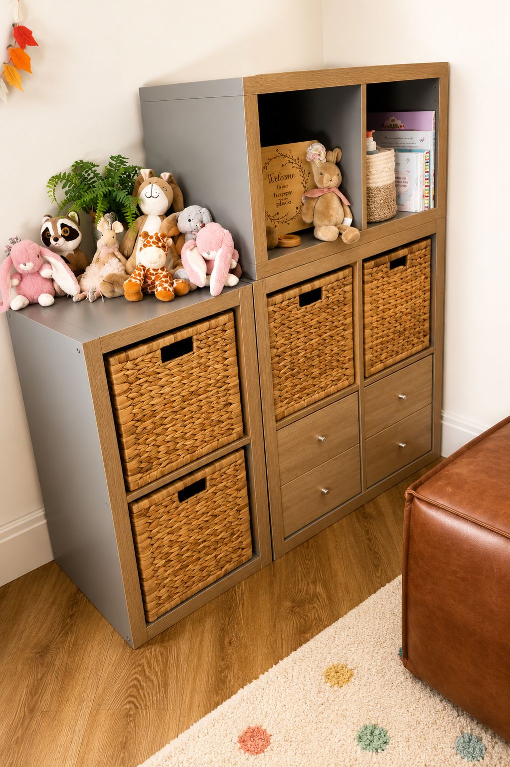 Wood-tone IKEA KALLAX storage unit styled with woven baskets, drawer inserts, plush toys, and decorative keepsakes. Warm natural textures and soft neutral colors create a cozy and organized toy storage setup with a modern, family-friendly feel.